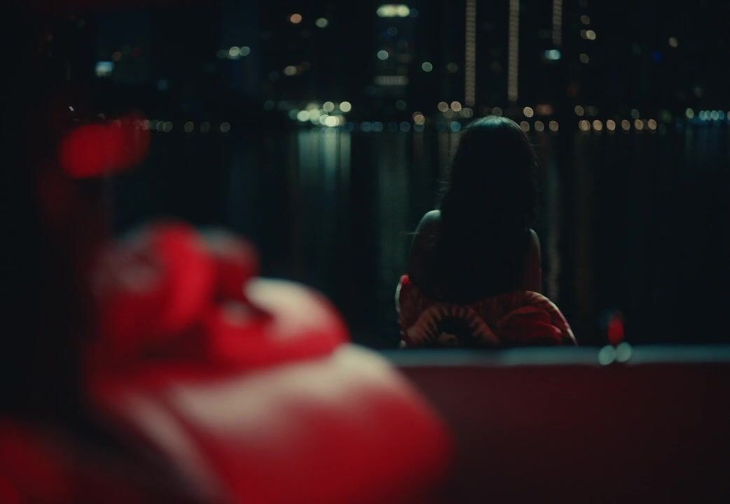 a woman sitting on a couch in a dark room