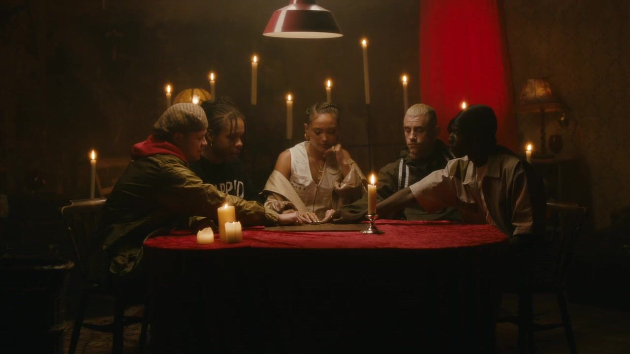 a group of people sitting around a table with candles