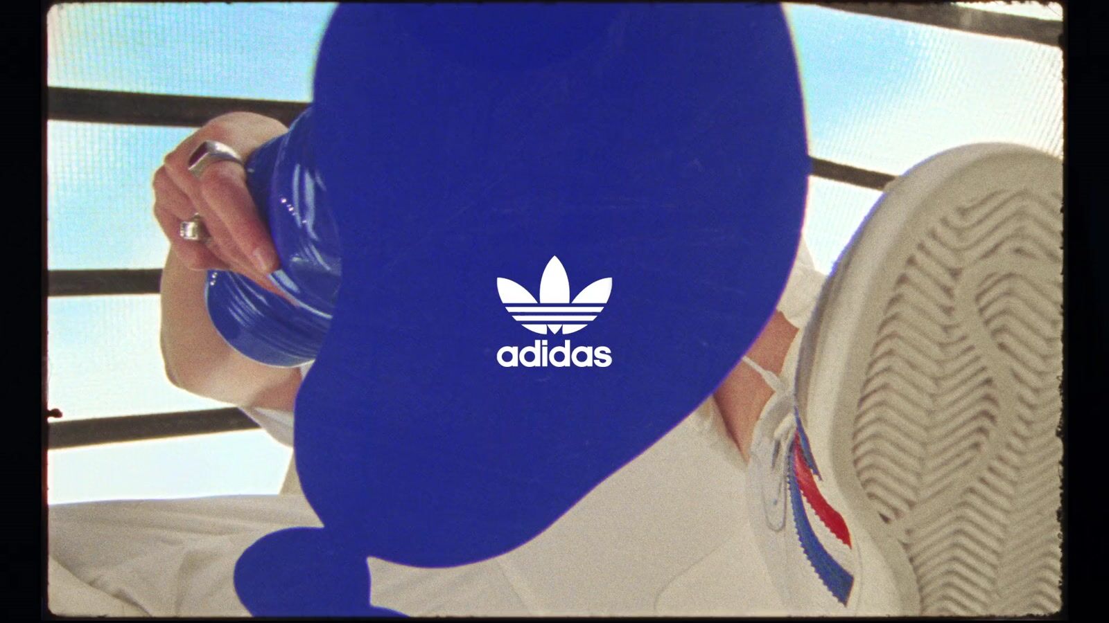 a person wearing a blue adidas hat