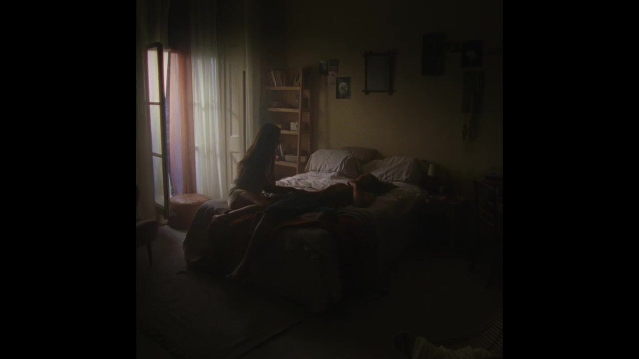 a person laying on a couch in a dark room